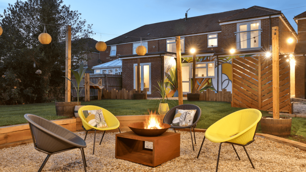 Fire pit with seats around in a garden, with a HIve at the back