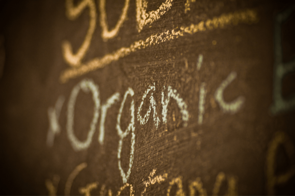 word "organic" written in chalk on a chalkboard menu