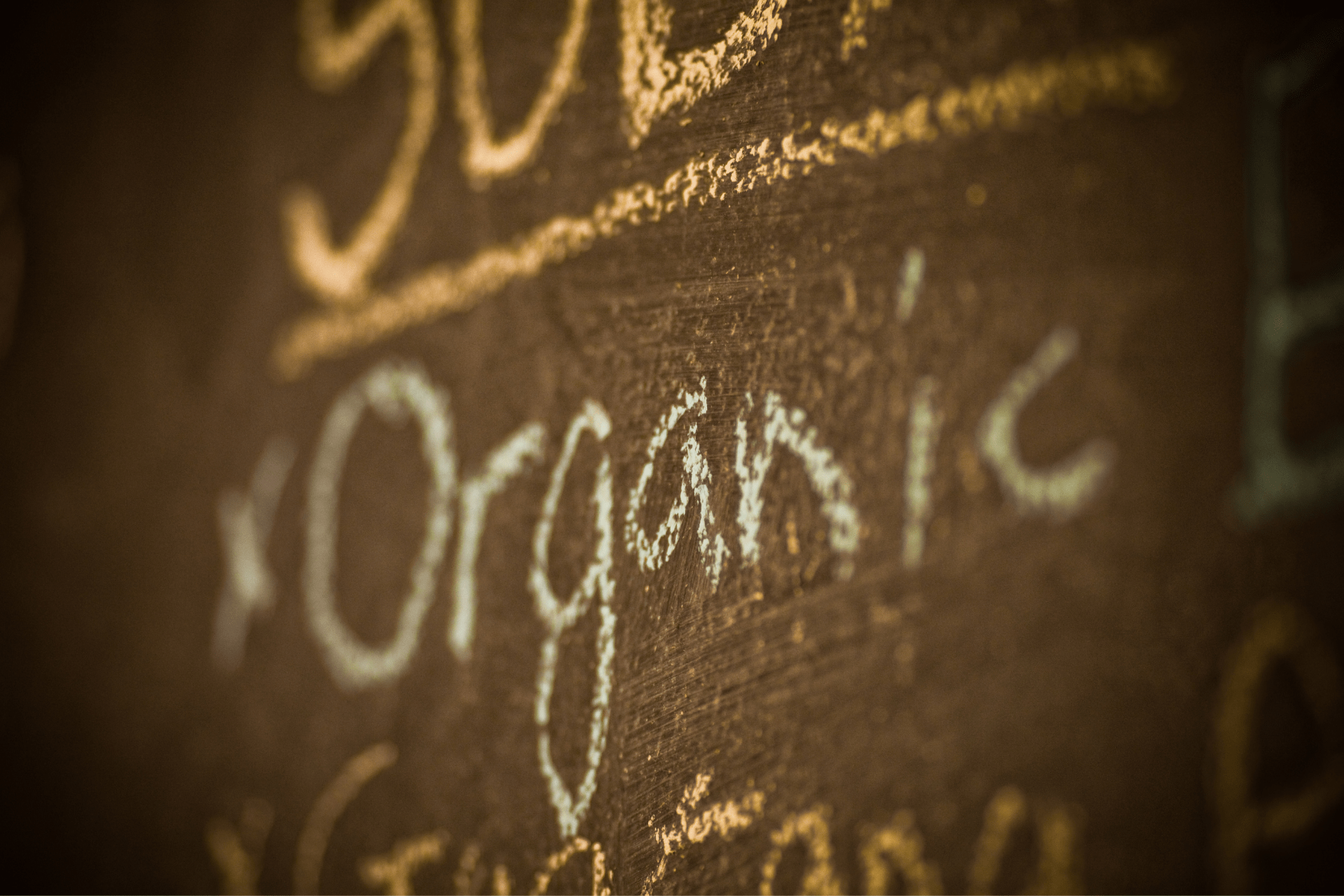 word "organic" written in chalk on a chalkboard menu