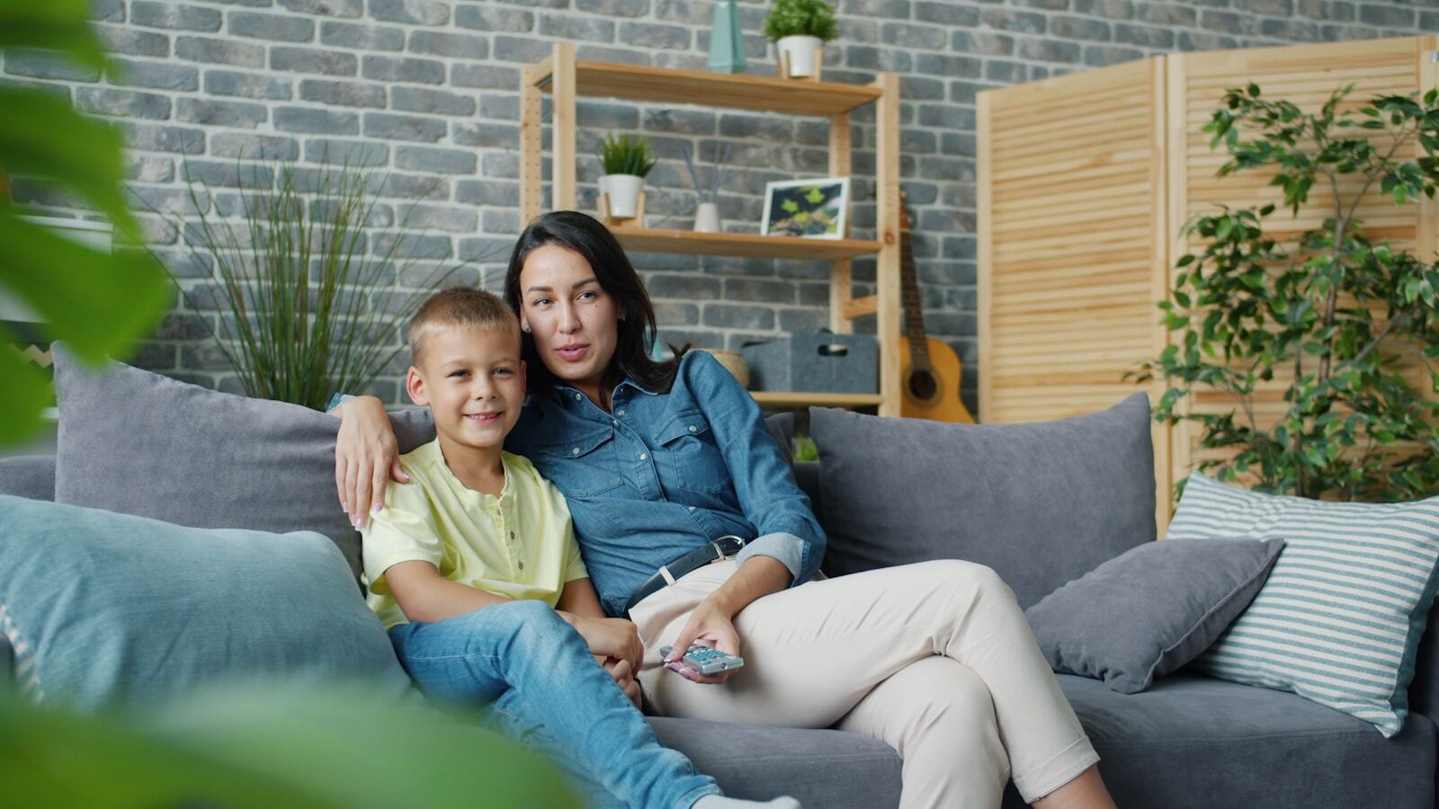 Photo by Vitaly Gariev Mother and son sitting together on a couch.