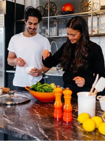 Couple preparing a healthy meal together in a modern kitchen.