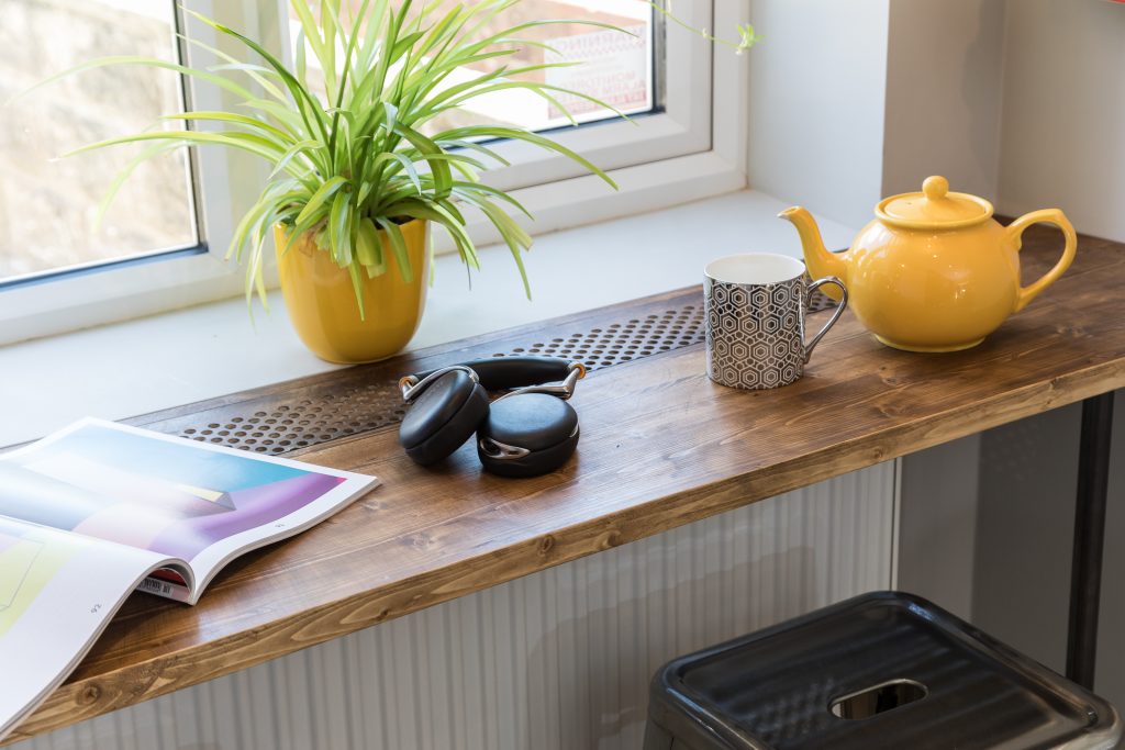 Morning cup of coffee, headphones and magazine at a kitchen window seat